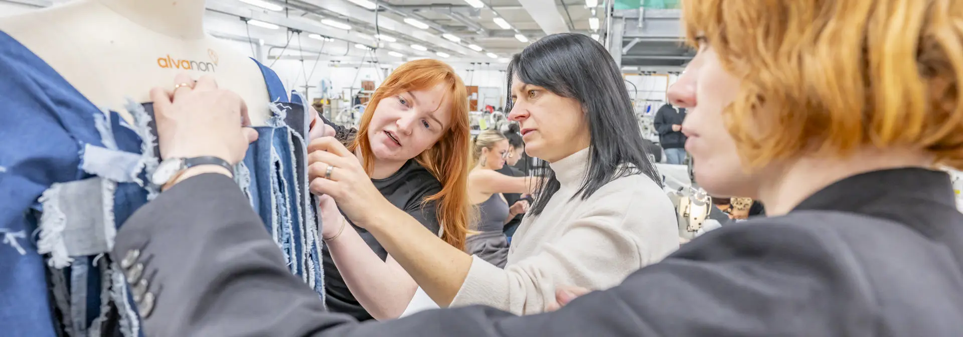 Students in fashion class and working with a mannequin.