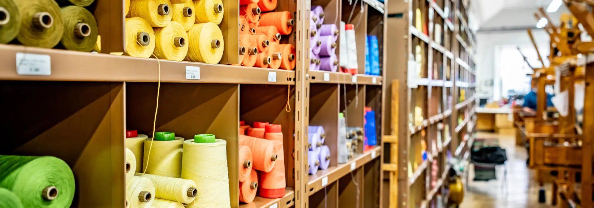 Close-up of colored colored yarns in a brown cabinet rack