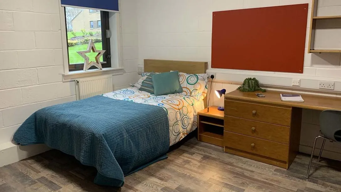 Bed beside window and desk