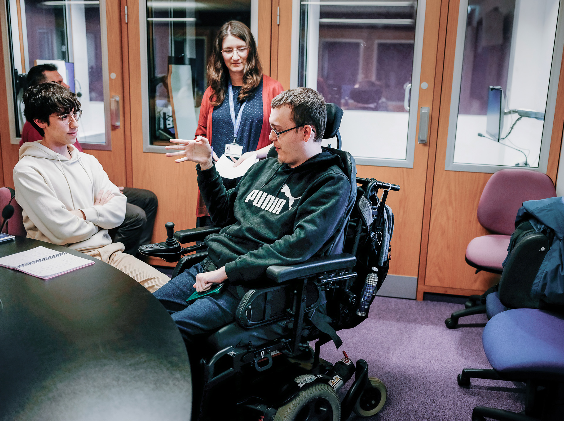 Three individuals in the interpreting and translation centre. 