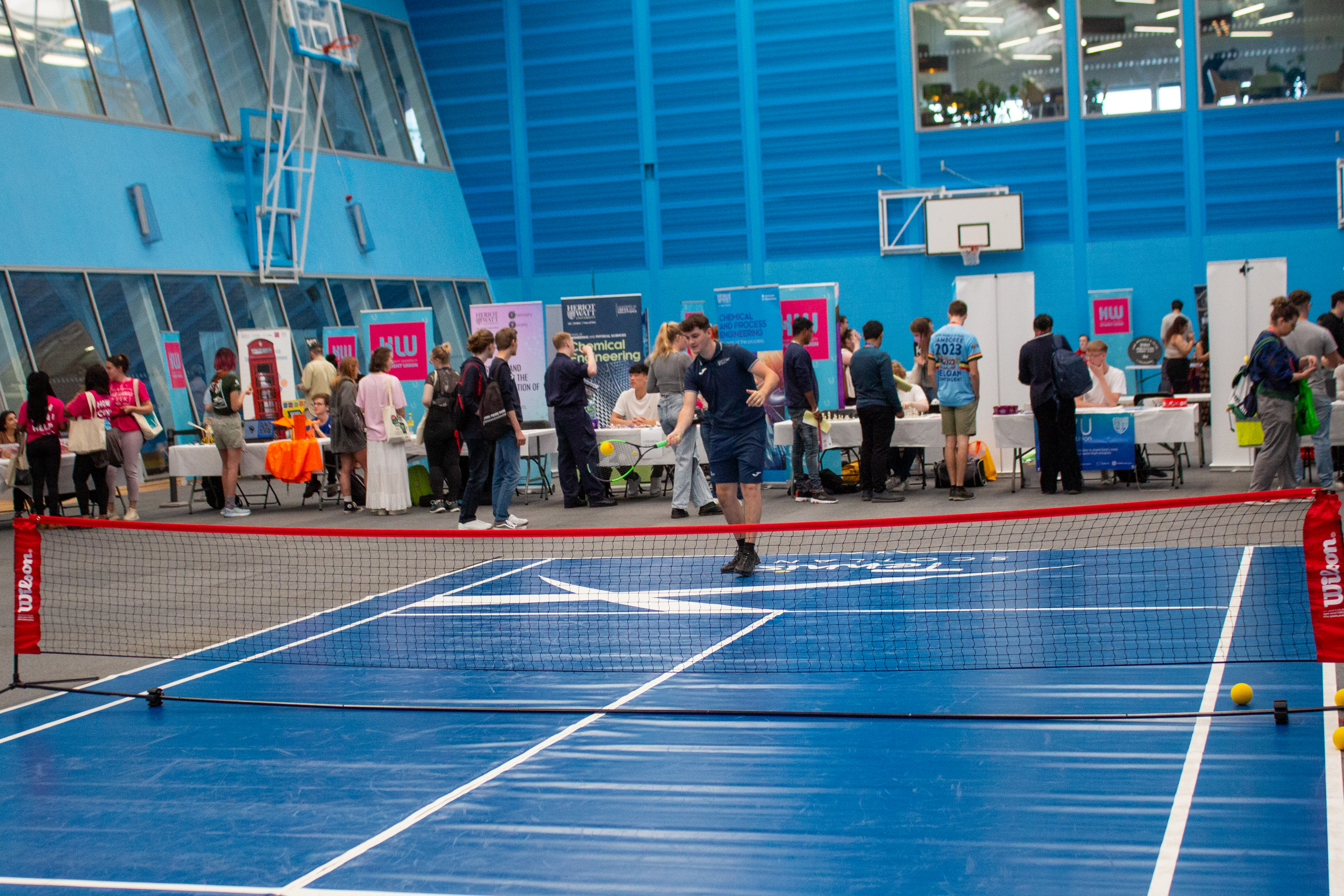 An individual plays tennis indoors