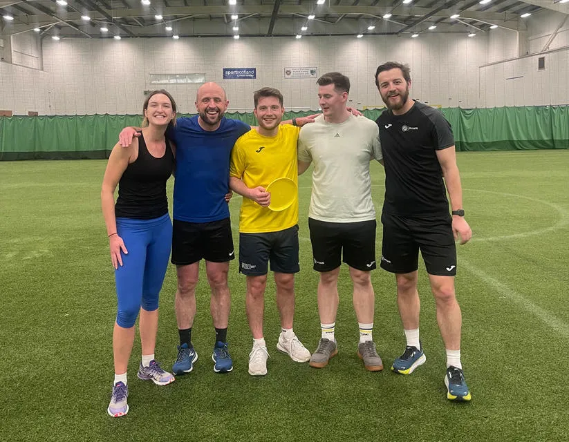 four people inside a sports hall 