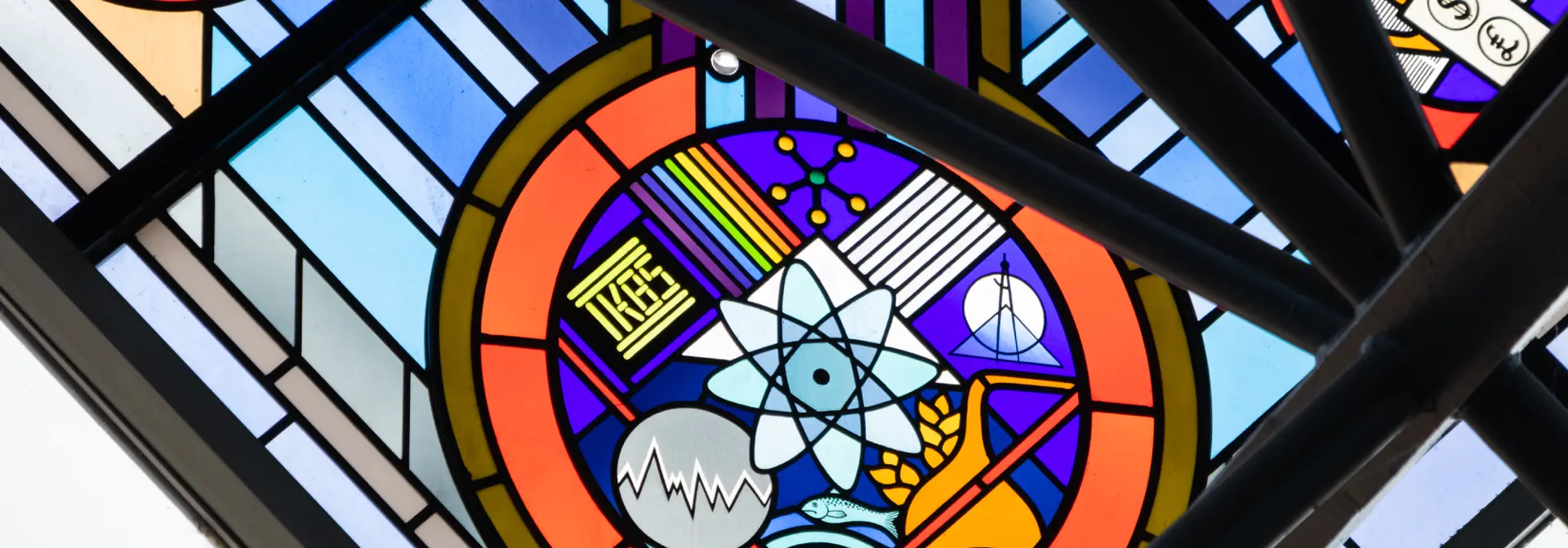 Colourful stained glass window with various symbols for science.