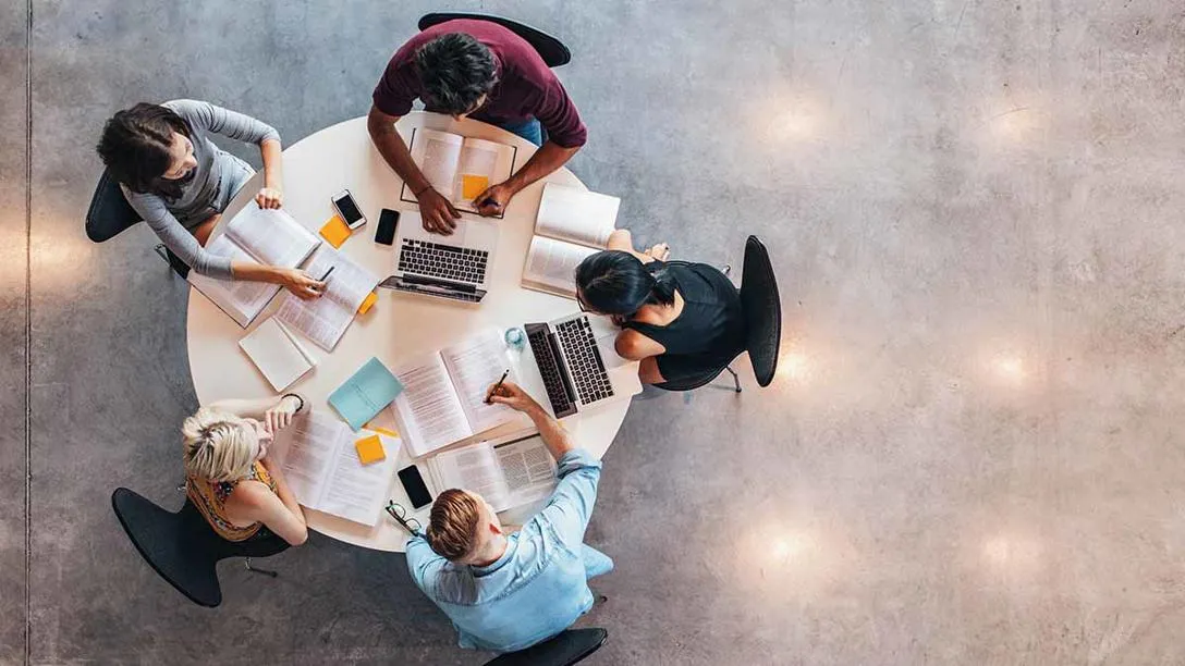 A group of students around a round table, seen from above