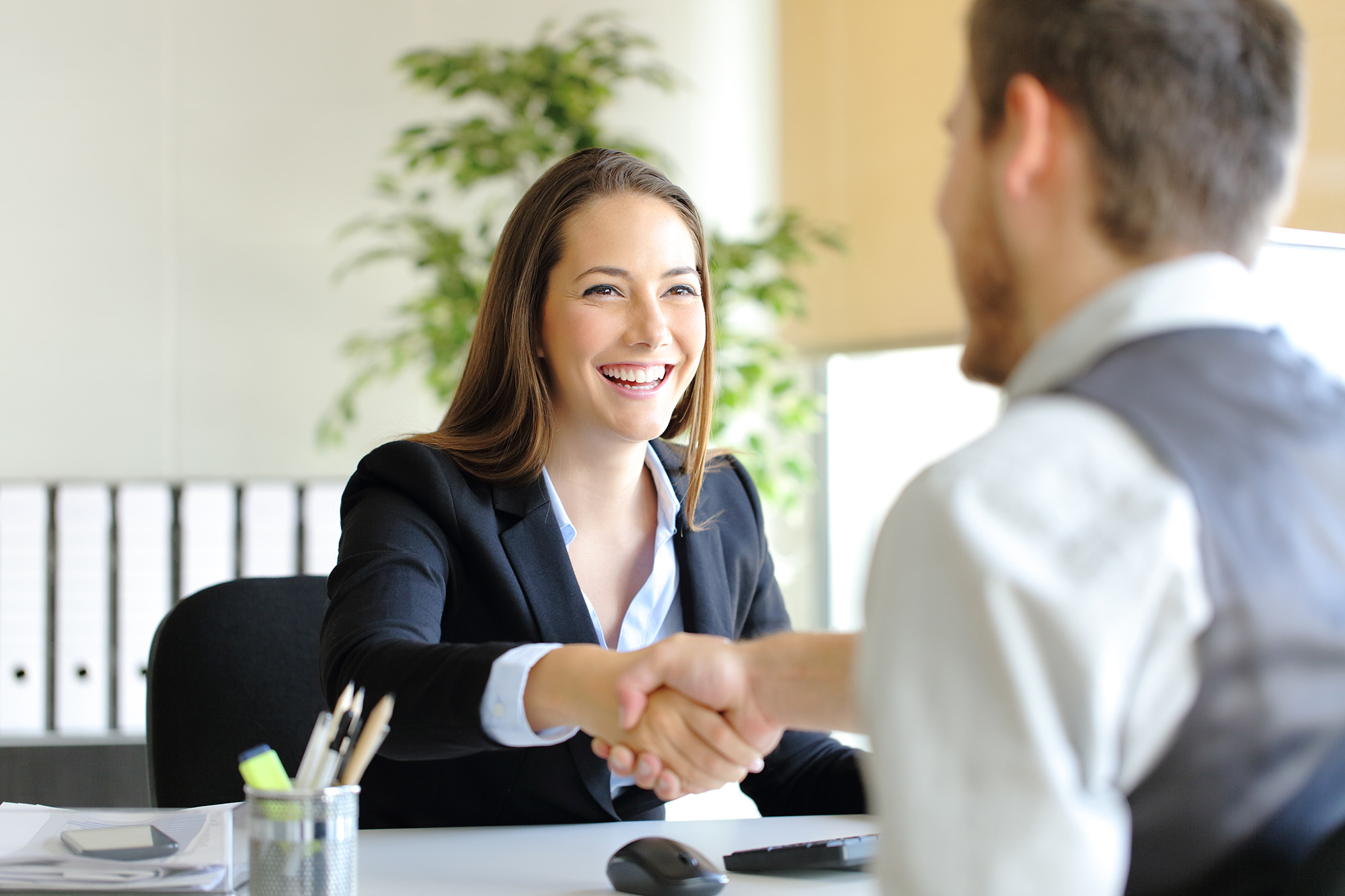 Two individuals shaking hands after a job interview.