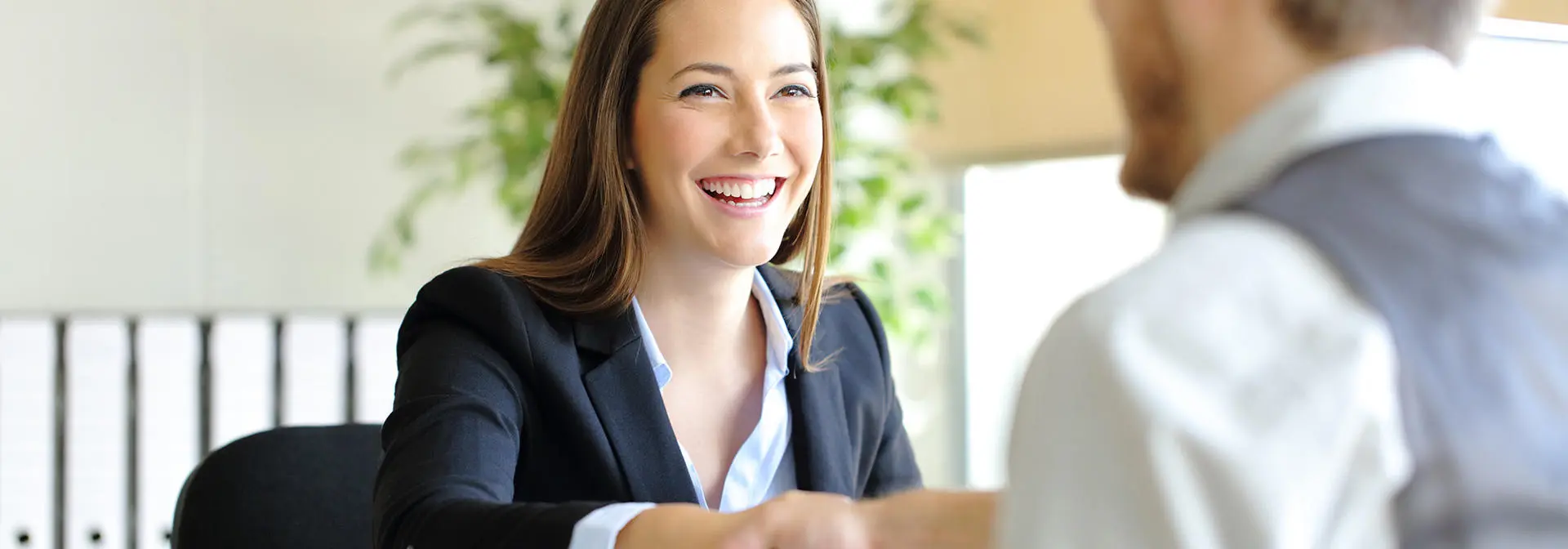 Two individuals shaking hands after a job interview.