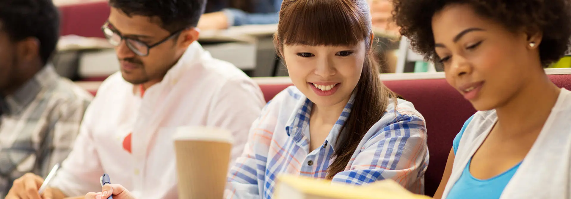 Three students in a lecture hall.
