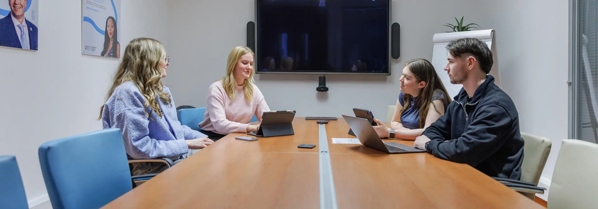 Four students sitting in the main meeting room of EBS on the Edinburgh campus.