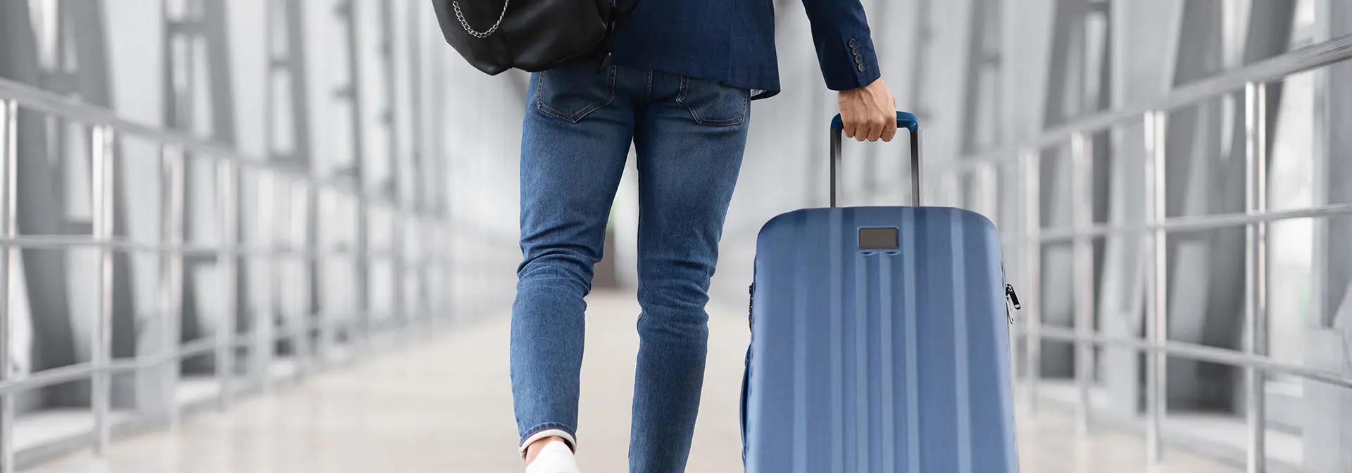 An individual taking luggage through an airport.