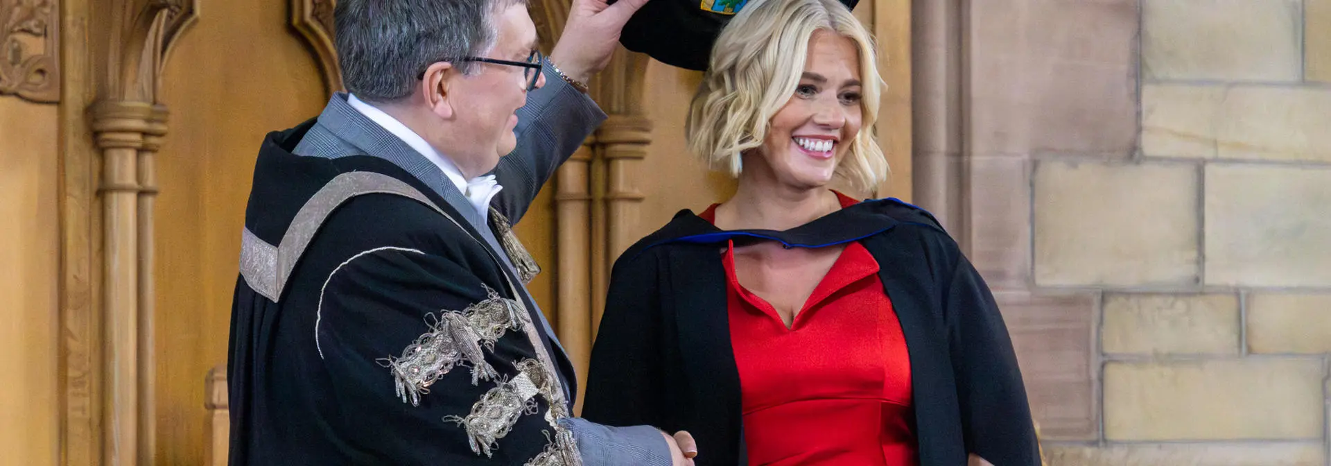 A student shaking hands with the Principal at the graduation ceremony.