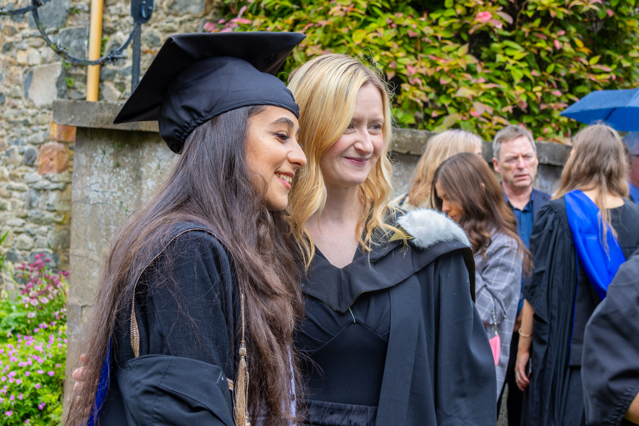 Students in graduation robes post for photographs.