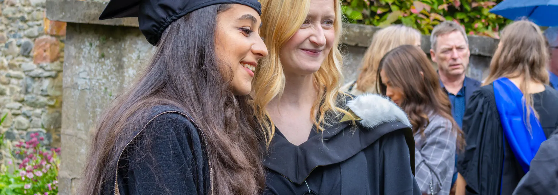 Students in graduation robes post for photographs.