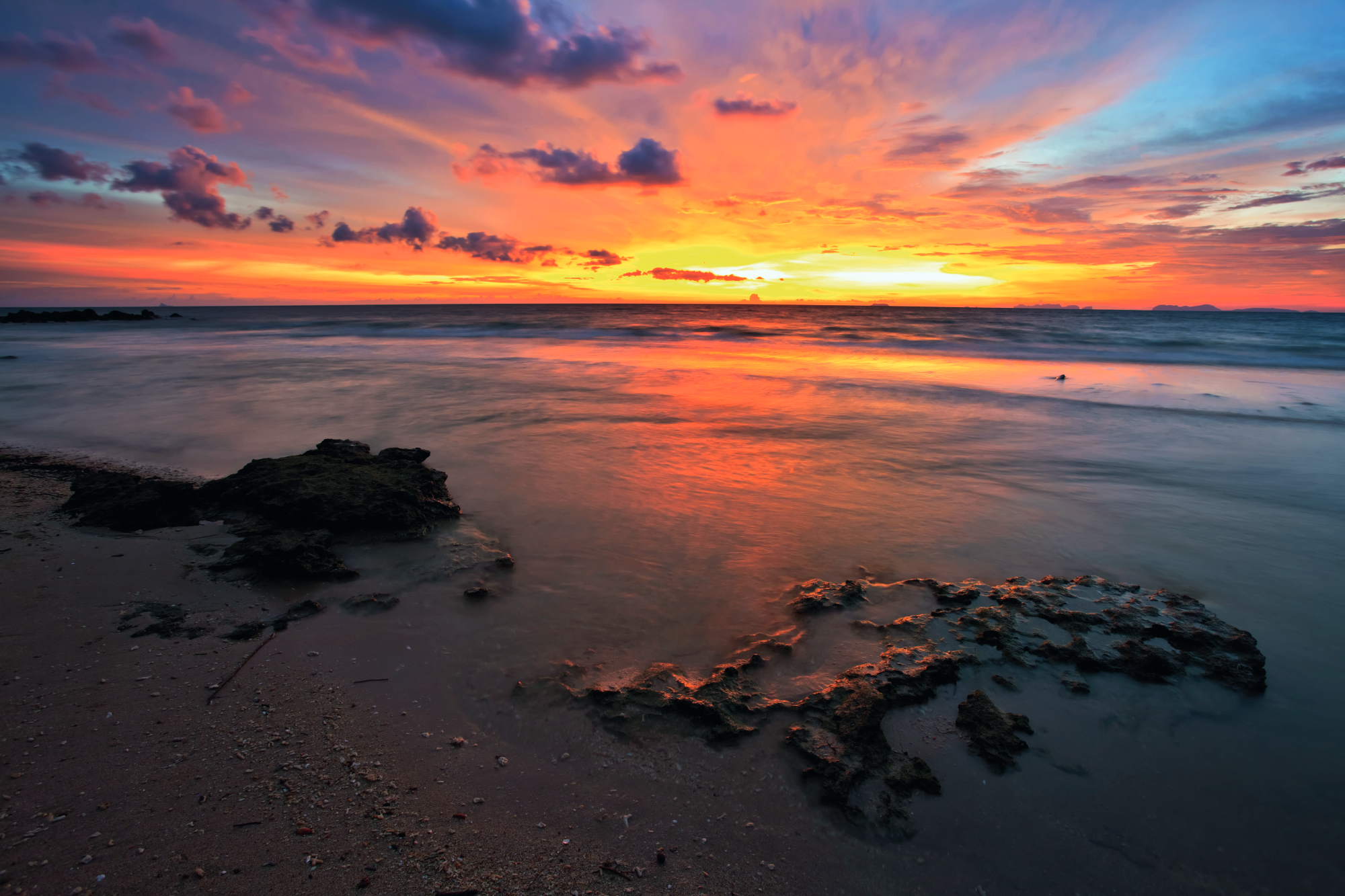 An orange sunset over the water at the beach. 