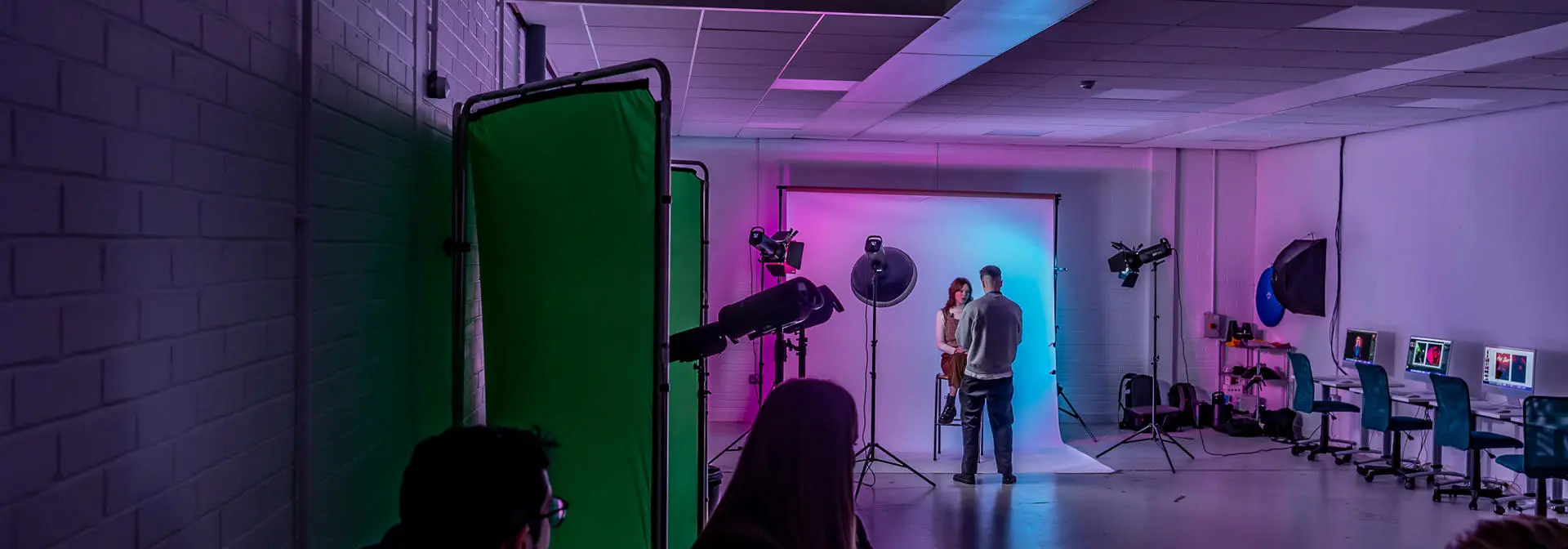Individuals working with a green screen and camera as part of a photography shoot.