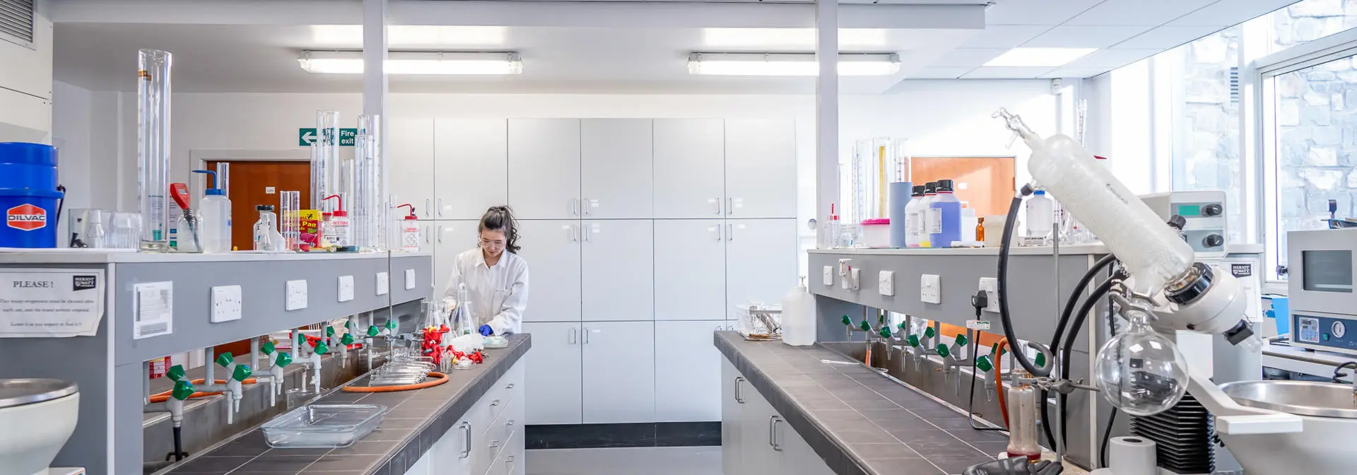 A chemical laboratory with multiple cupboards and equipment on display.