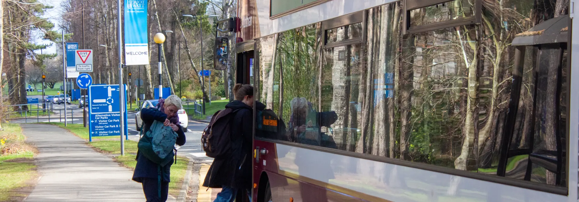 Two individuals getting onto a bus.
