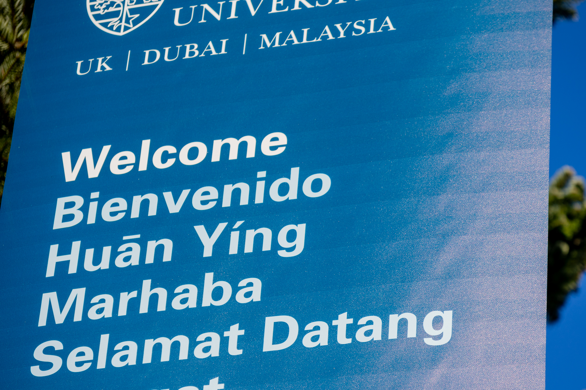 A blue sign with the word welcome written in different languages. 