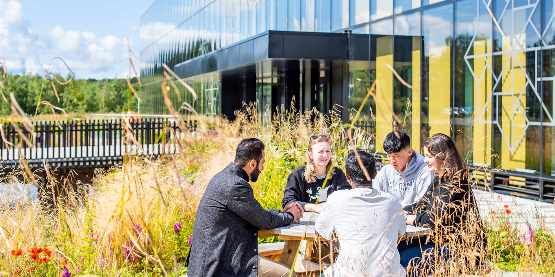 Students sit chatting outside the National Robotarium