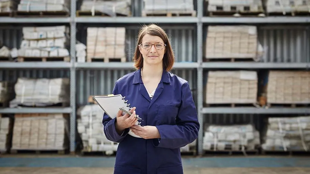 A woman in uniform at a warehouse.  