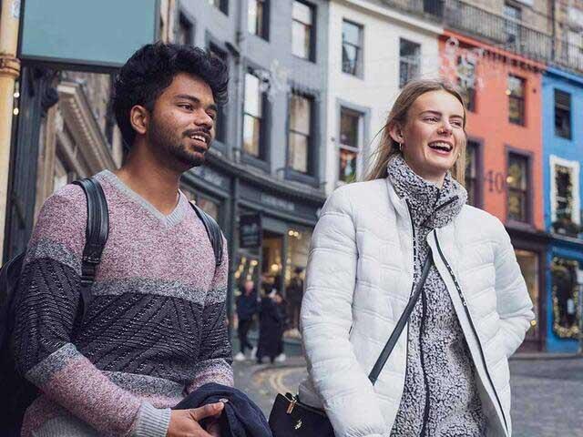 Students smiling and chatting on Victoria Street Edinburgh