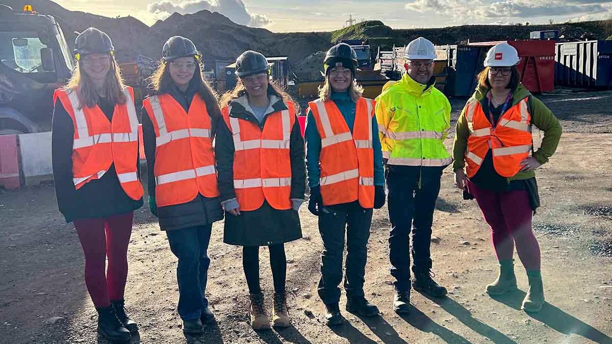 Five student members of the Eco Society and Net Zero Society at a waste processing facility