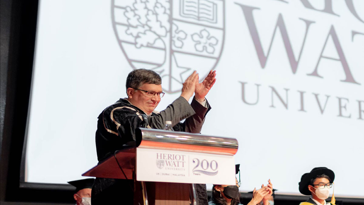 Principal Richard A Williams applauds the summer graduands of Heriot-Watt University Malaysia from the podium at the ceremony