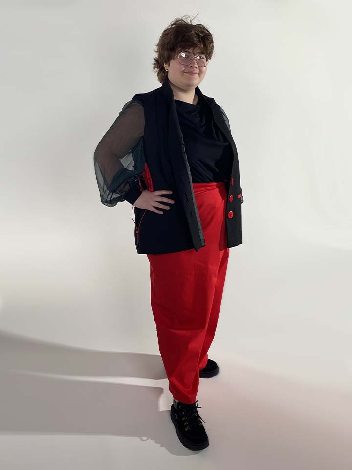 A woman wearing red trousers and a black shirt.