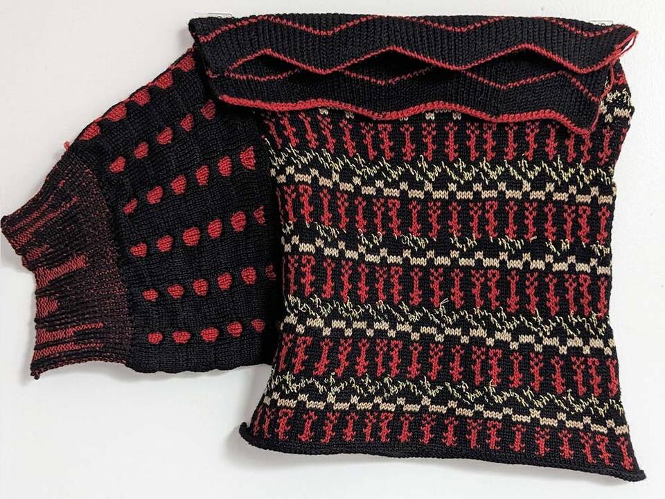 A stylish knitted scarf with alternating red and black stripes, perfect for a cozy and fashionable look.