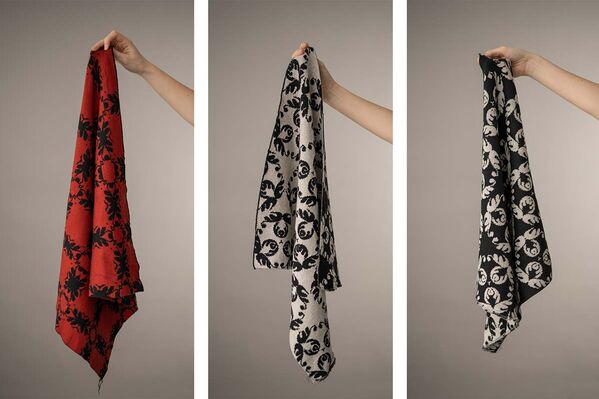 Three scarves with unique designs: one with stripes, one with floral patterns, and one with geometric shapes.