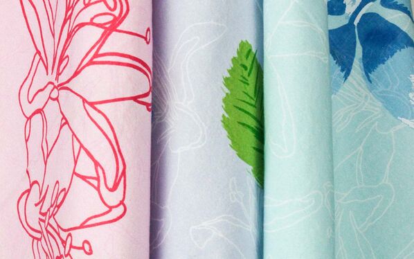 Close up of three colorful fabrics in red, blue, green, and yellow hues.