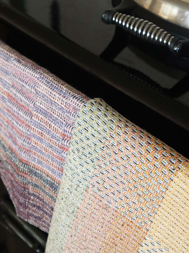 A vibrant woven cloth hangs on a stove.