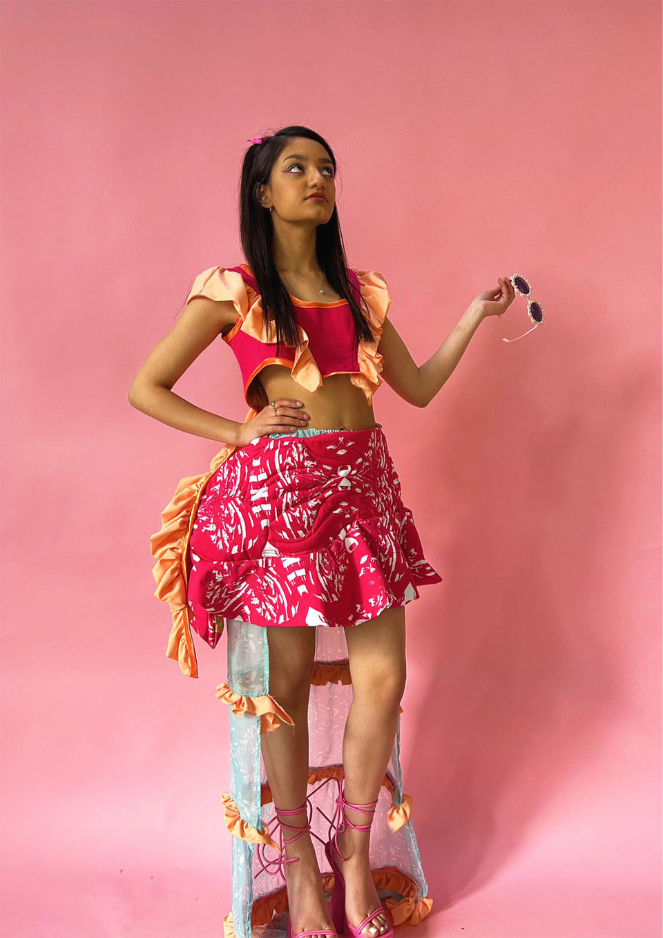 Woman models a skirt and top in pink and peach design from 'Forget Me Not' a collection by Jessica Neilson 