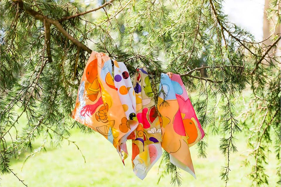 Brightly colored scarves draped on tree branches, adding a pop of color to the surroundings.