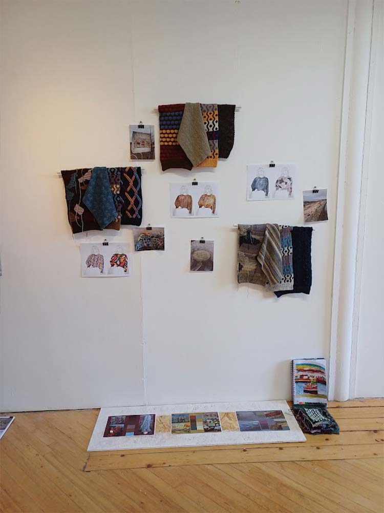 Gallery wall displaying sketches with a textile rug hanging.