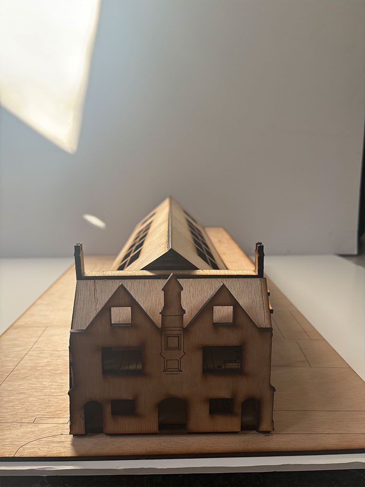 Architectural model of building on table, showcasing intricate design and scale details.