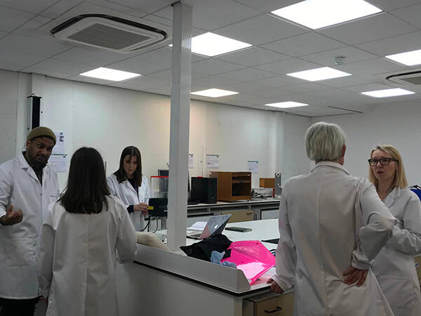 Students in lab coats in discussion