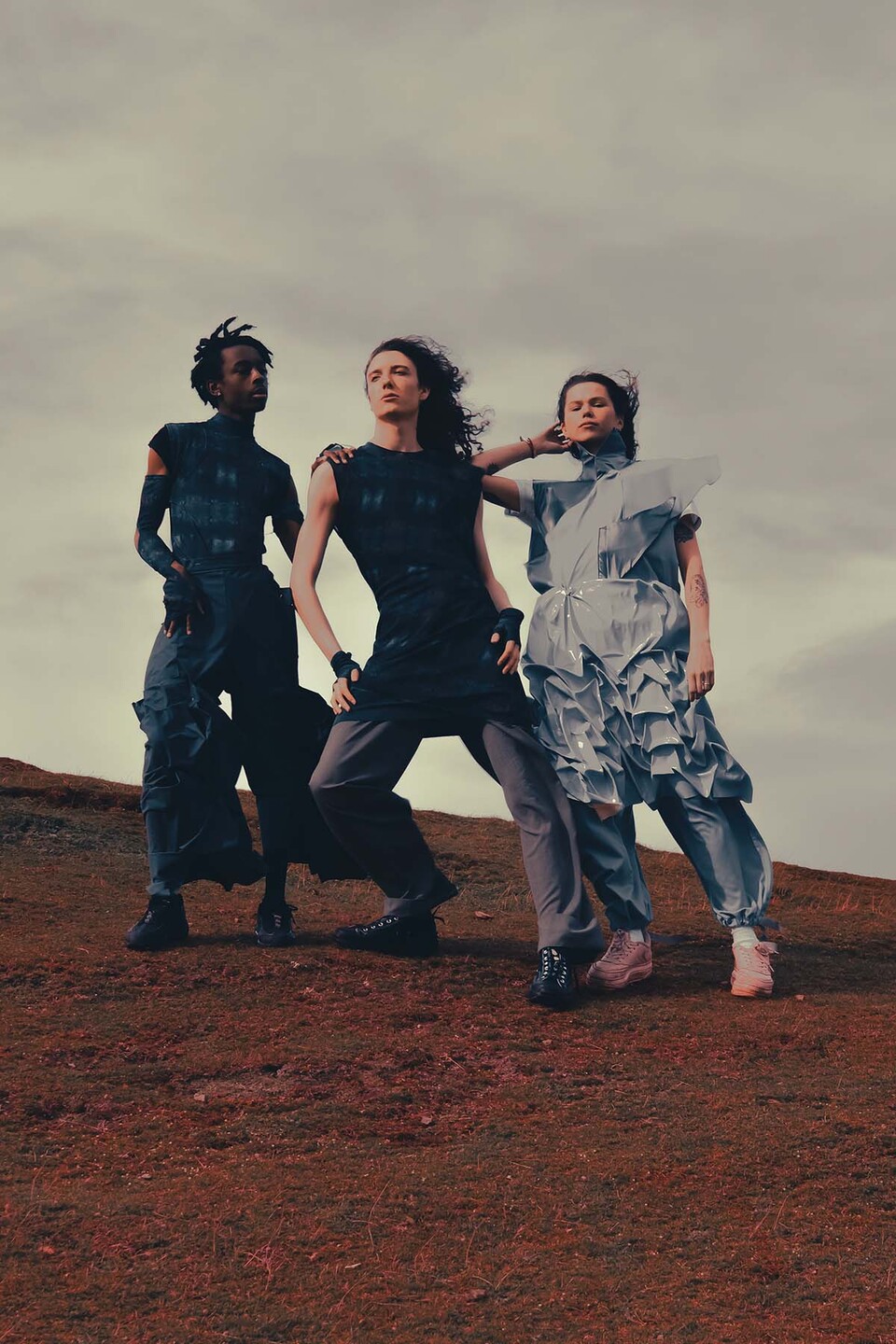 Three male modesl stand on a rocky hillside wearing designs by Lucy Power from her collection 'Concrete & Flowers' 