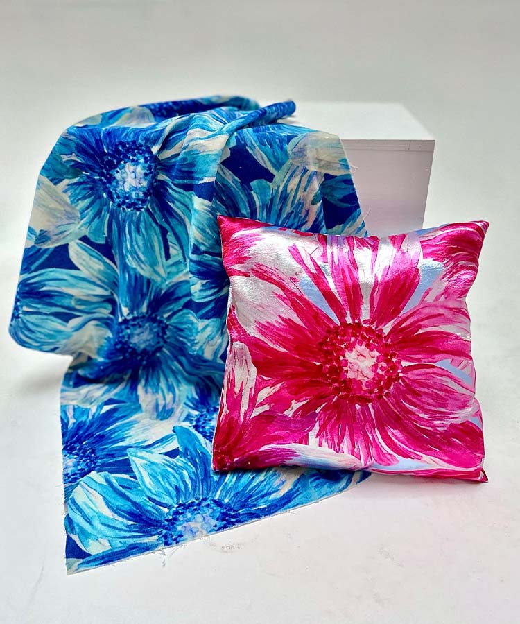 A blue and pink floral print pillow and a matching blue and pink pillow side by side.