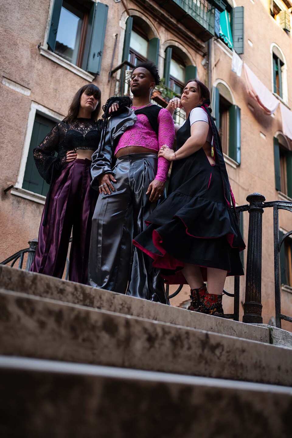 A man and two women model Flamenco inspired streetwear from a collection by Paula Pacheco on a footbridge in Seville