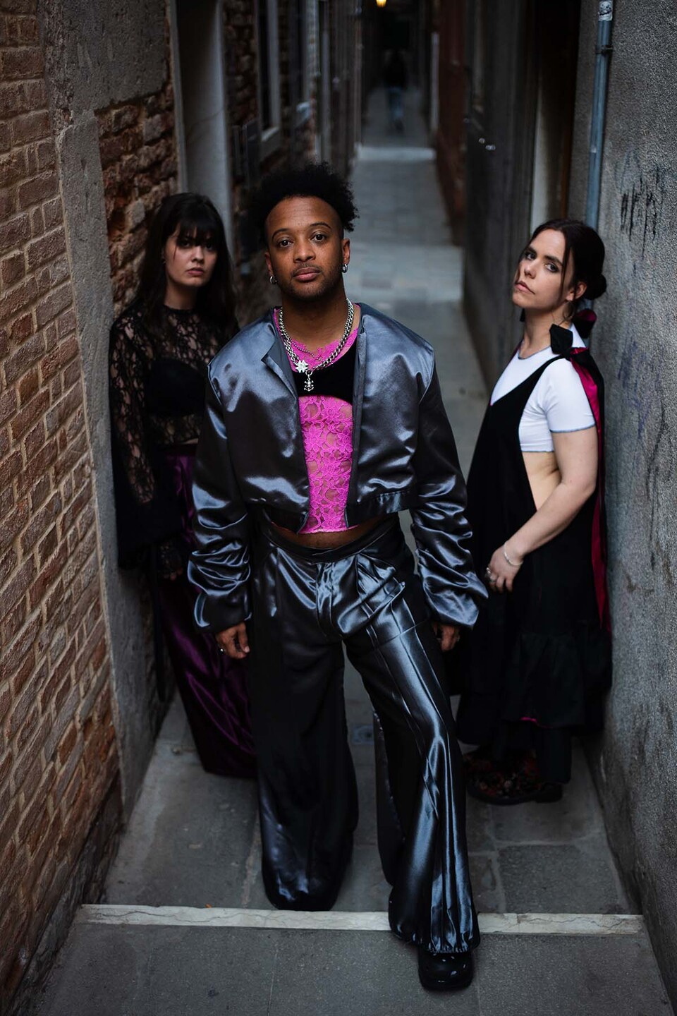 A man and two women model Flamenco inspired streetwear from a collection by Paula Pacheco in an alley in Seville