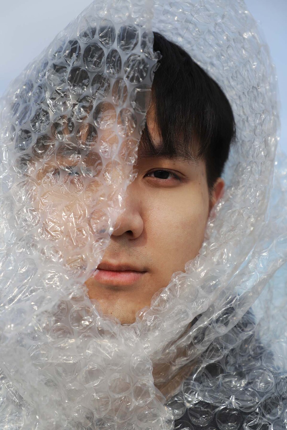 Young man's head wrapped in bubble wrap