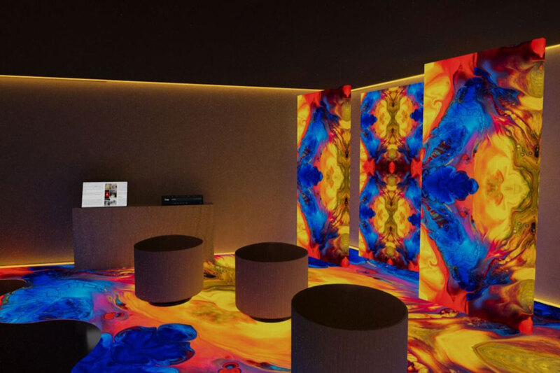 A vibrant room with colorful lights and a large screen displaying captivating visuals.